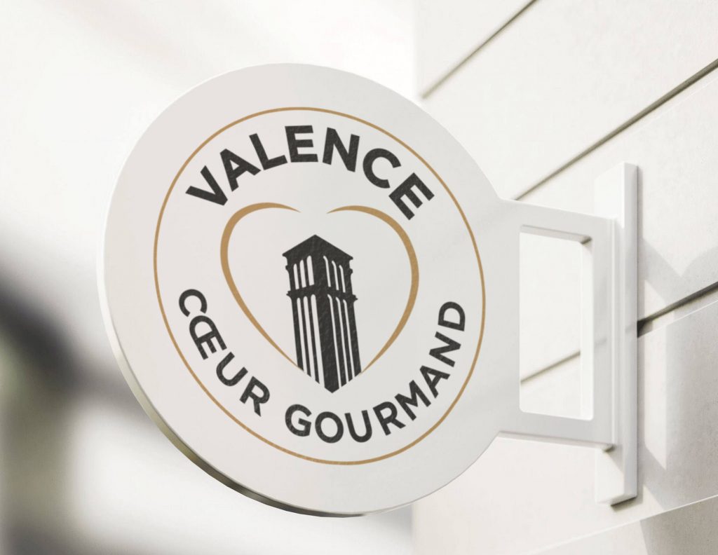 Photomontage de l'enseigne Valence Cœur Gourmand, présentant le logo gastronomique sur un support extérieur, offrant une visibilité optimale de la marque.