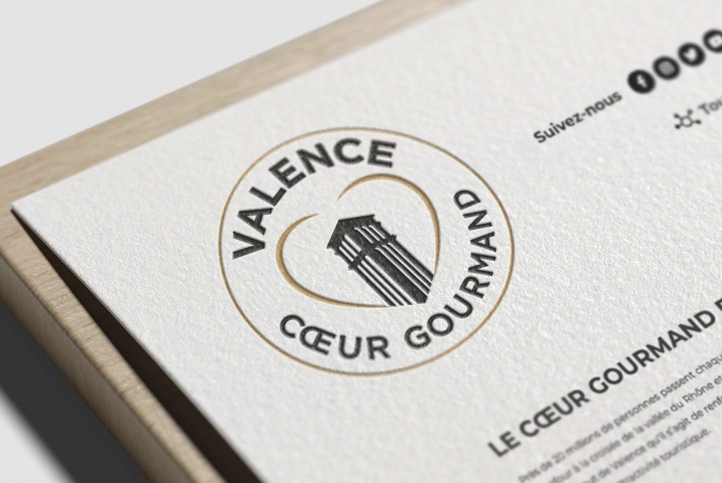 Photomontage d'un mockup du logo Valence Cœur Gourmand, illustrant son design gastronomique sur divers supports pour une présentation professionnelle